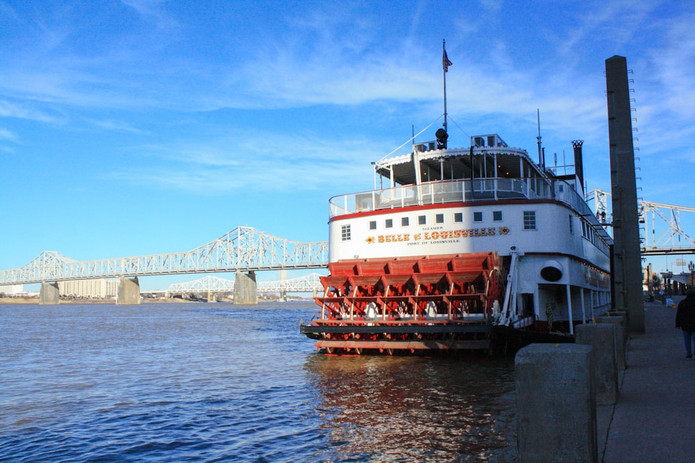 weiß-rotes Schiff auf See unter blauem Himmel tagsüber