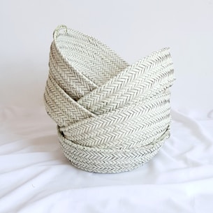 gray woven round basket on white textile