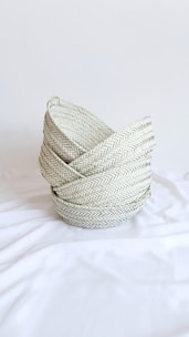 gray woven round basket on white textile