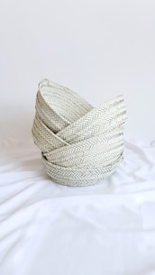 gray woven round basket on white textile