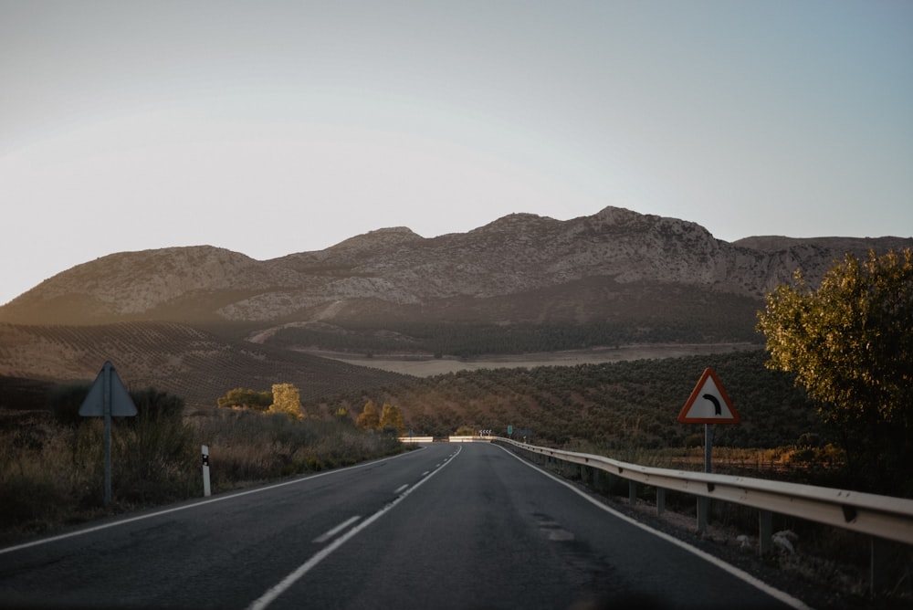 black asphalt road near brown mountain during daytime