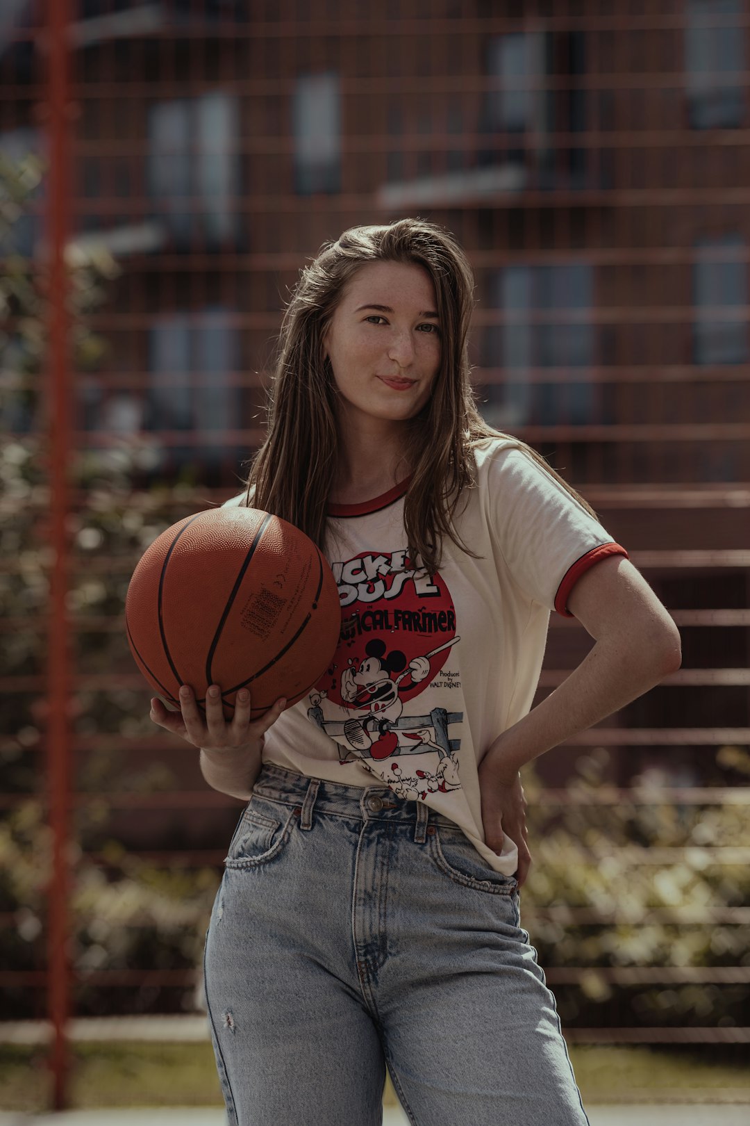 woman in white crew neck t-shirt holding basketball