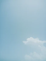 A wide-open sky with soft clouds drifting over a peaceful landscape.