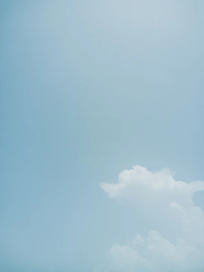 A wide-open sky with soft clouds drifting over a peaceful landscape.