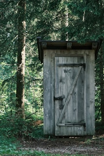 brown wooden door near green trees during daytime