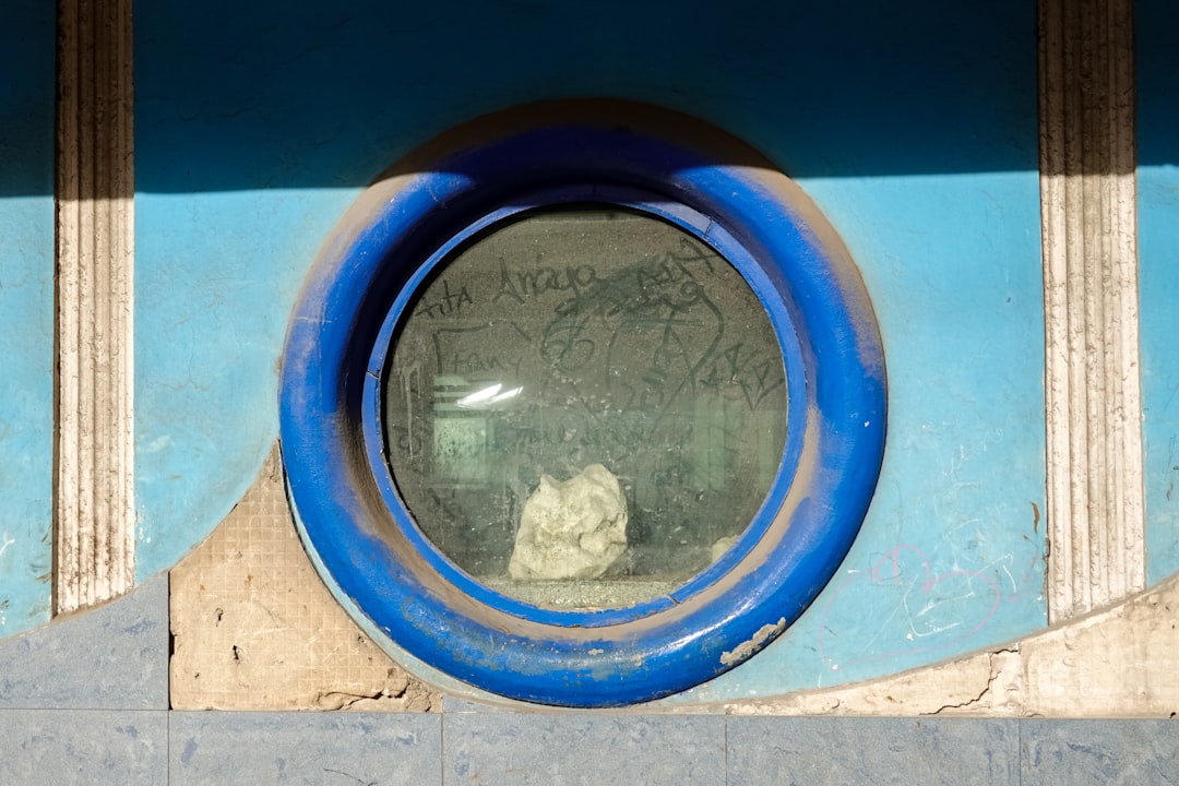 blue round plastic frame on brown concrete wall