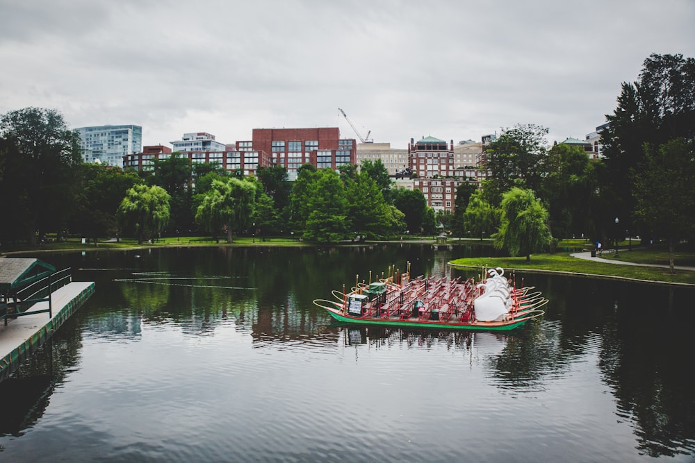 red and white boat on water near city buildings during daytime