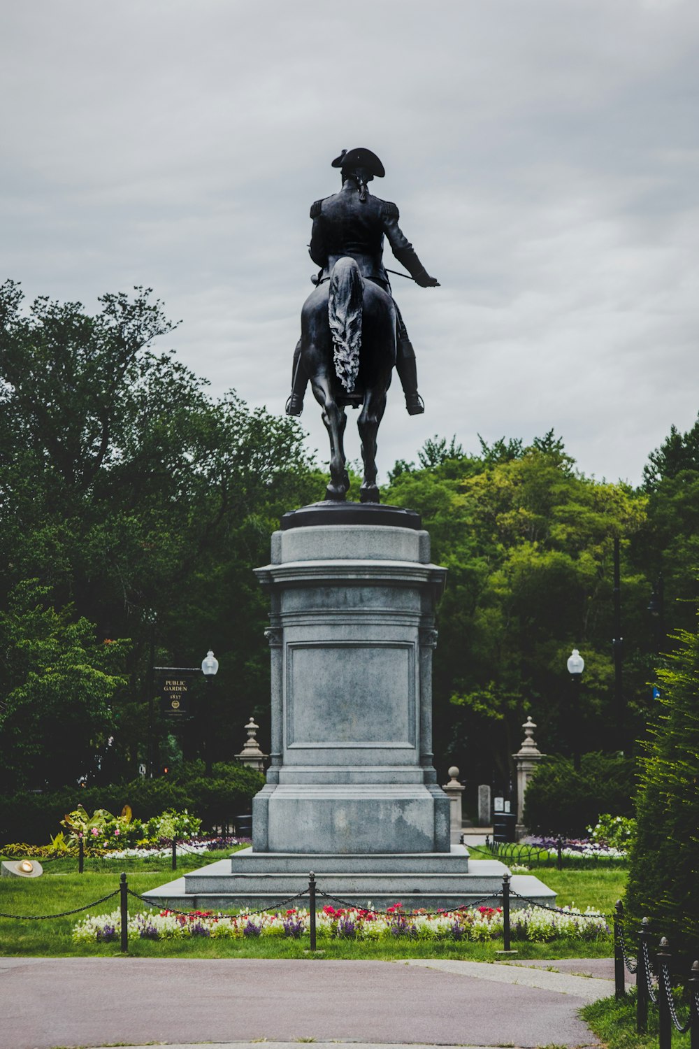 Estatua negra del hombre en la parte superior de un poste de hormigón gris