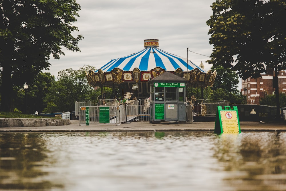 brown and green wooden house near body of water during daytime