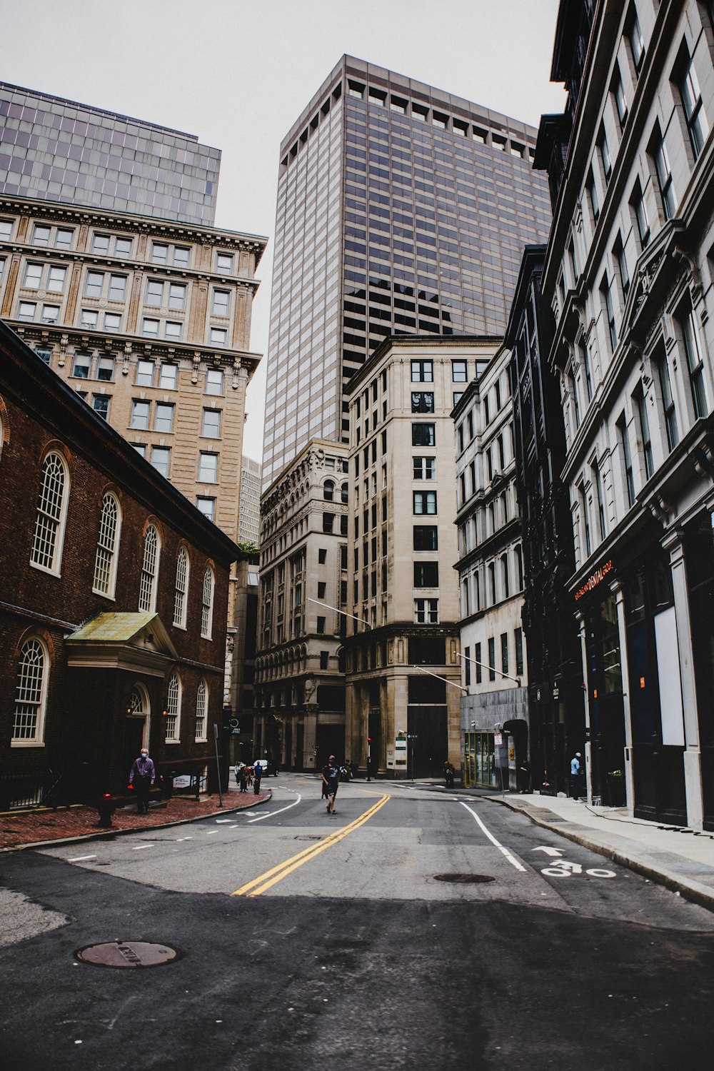 gray concrete road between high rise buildings during daytime