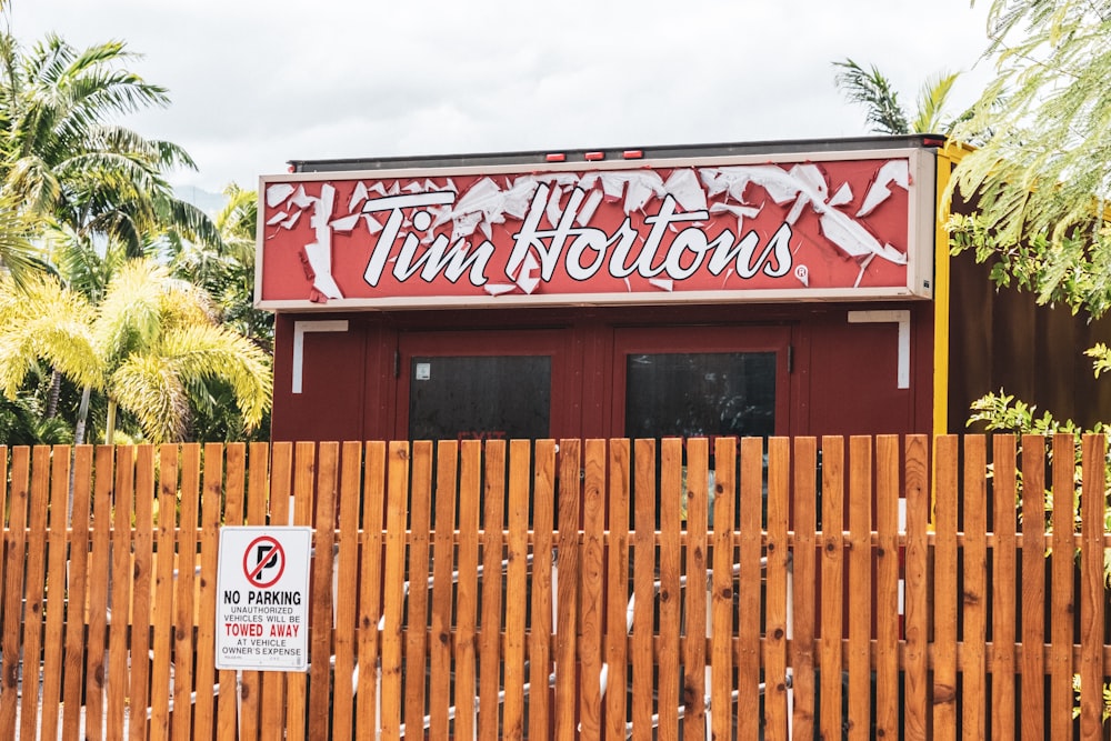 brown wooden fence with red and white store signage