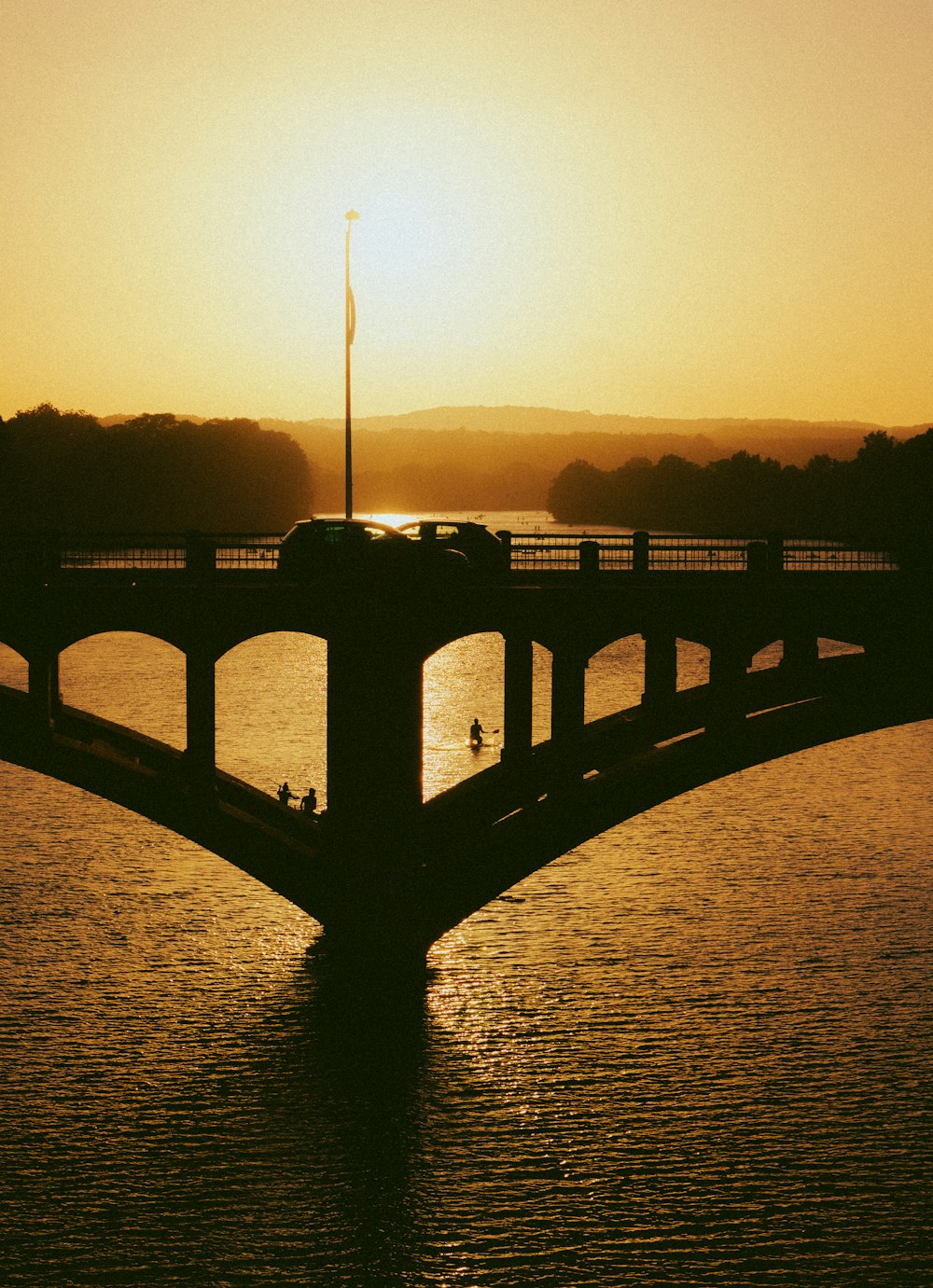 日没時の水面に架かる橋のシルエット