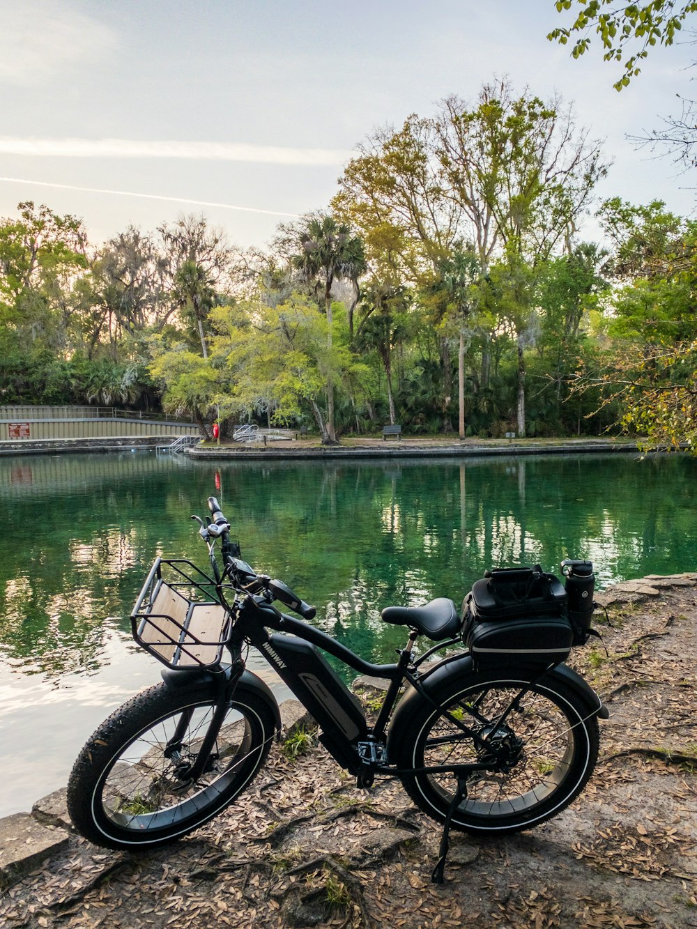 black and gray motorcycle parked beside body of water during daytime