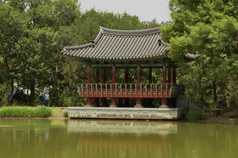 red and black temple near body of water during daytime