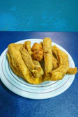A lively plate of crispy fried catfish resting on a bed of creamy grits with Cajun seasoning.