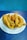 A plate filled with several pieces of deep-fried, battered catfish and a single hushpuppy. The fried catfish is golden brown and appears crispy, placed on a white plate with blue stripes. The setting has a blue textured background and tabletop.