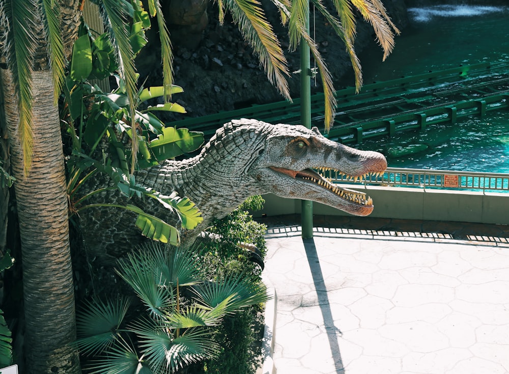 crocodile statue near green leaf plant during daytime
