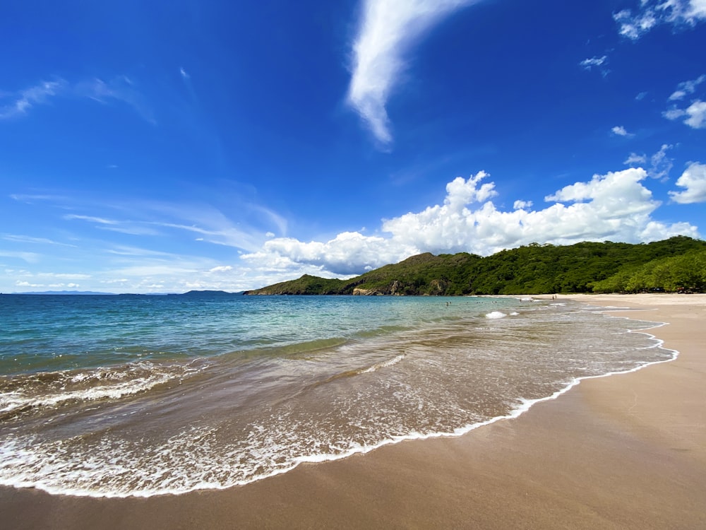 sea waves crashing on shore during daytime