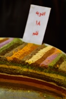 A display of Middle Eastern spice mixes with intricate patterns on packaging, set on a warm beige surface.