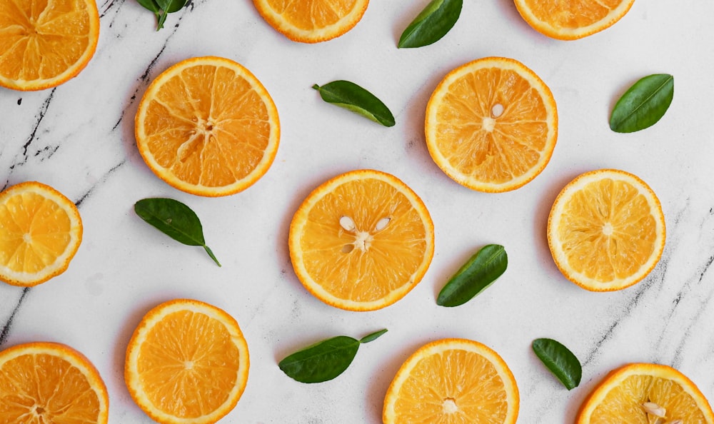 sliced orange fruits on white surface