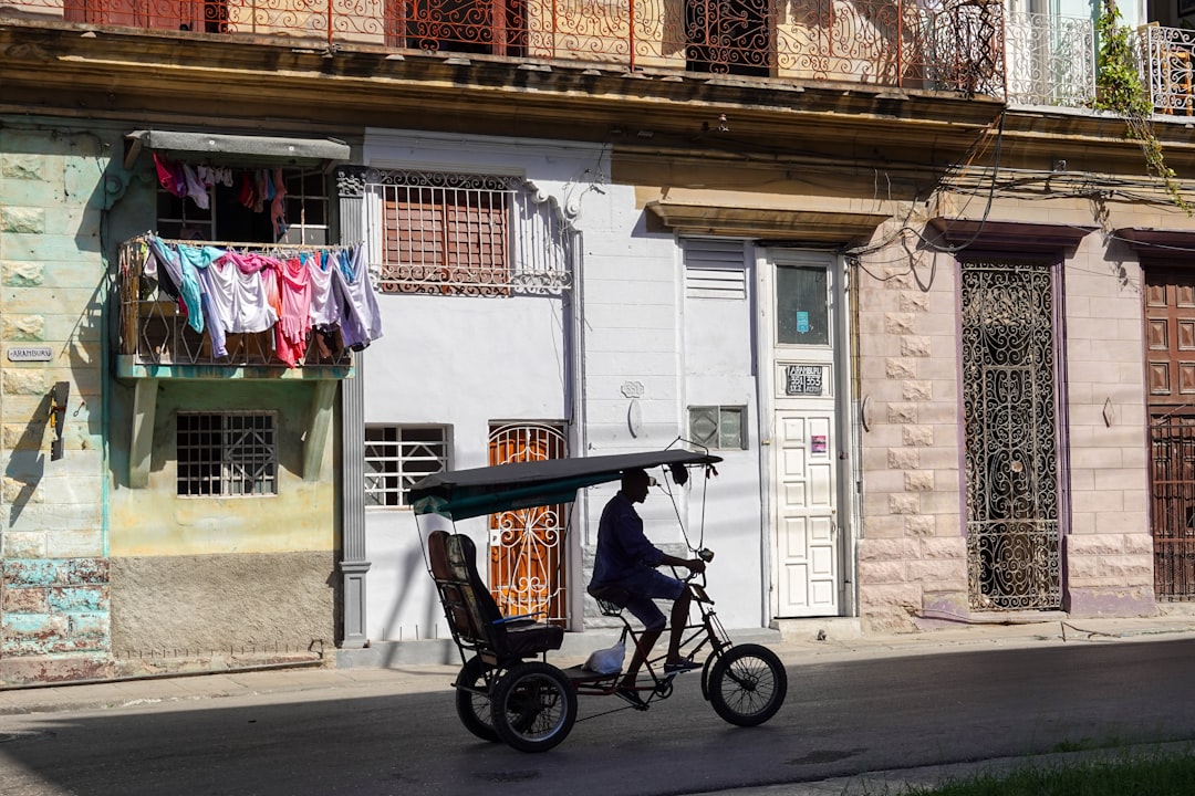 black and red trike parked beside brown concrete building during daytime