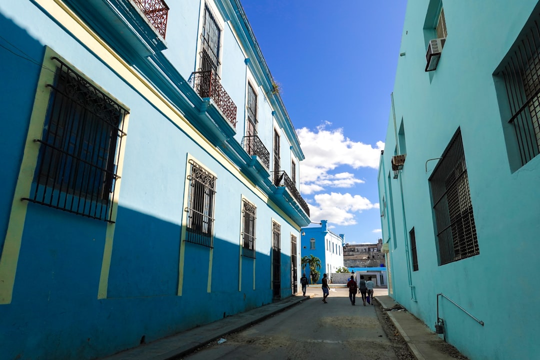 people walking on sidewalk near white and blue concrete building during daytime