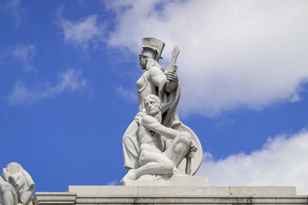 man in hat statue under blue sky during daytime