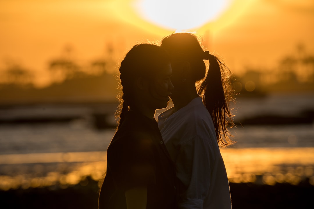 silhouette of woman standing and facing the sun