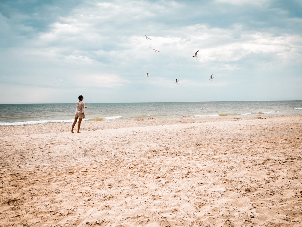 woman in black bikini walking on beach during daytime