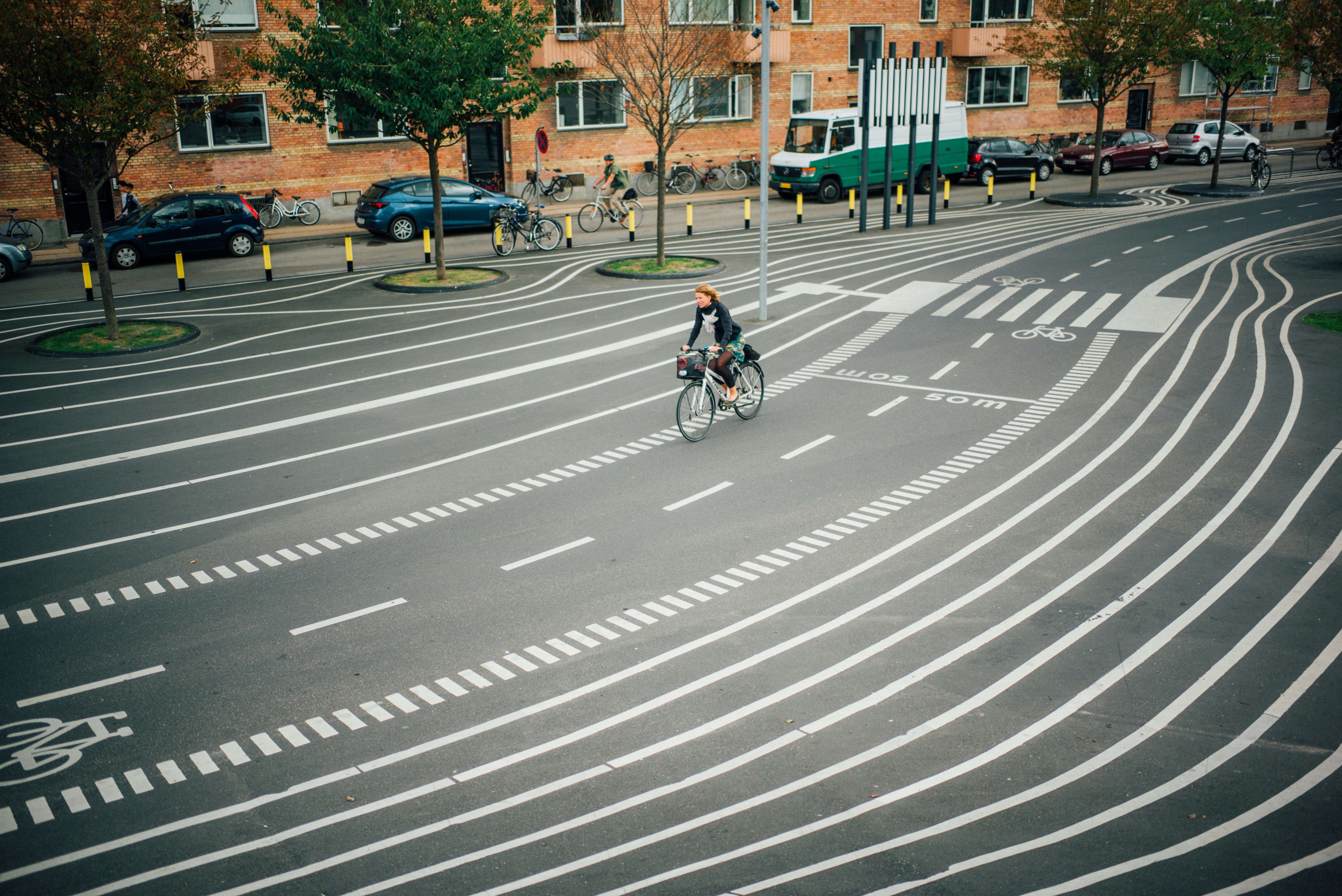 Mann in schwarzer Jacke fährt tagsüber Fahrrad auf der Fußgängerzone