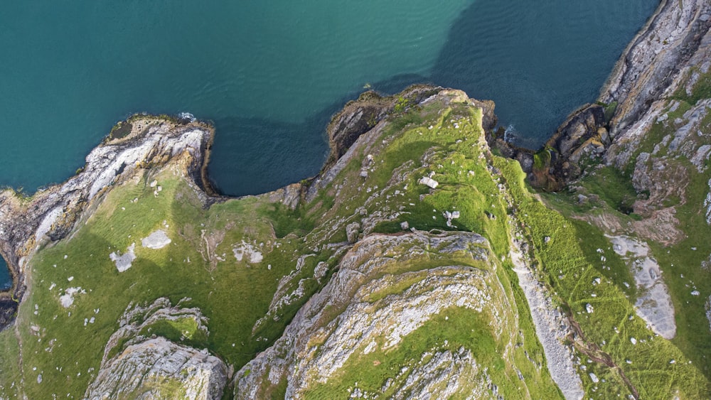 green and gray rock formation beside blue sea during daytime