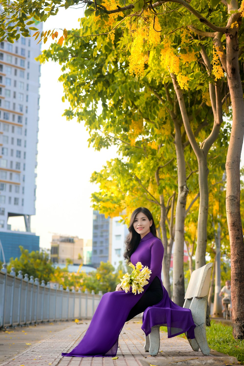 Mujer en vestido púrpura de pie debajo del árbol durante el día