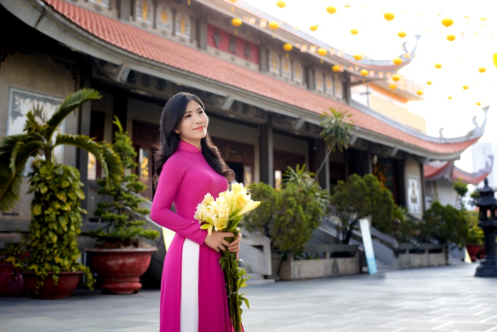 woman in purple long sleeve dress holding bouquet of flowers