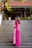 woman in pink long sleeve dress standing on gray concrete stairs