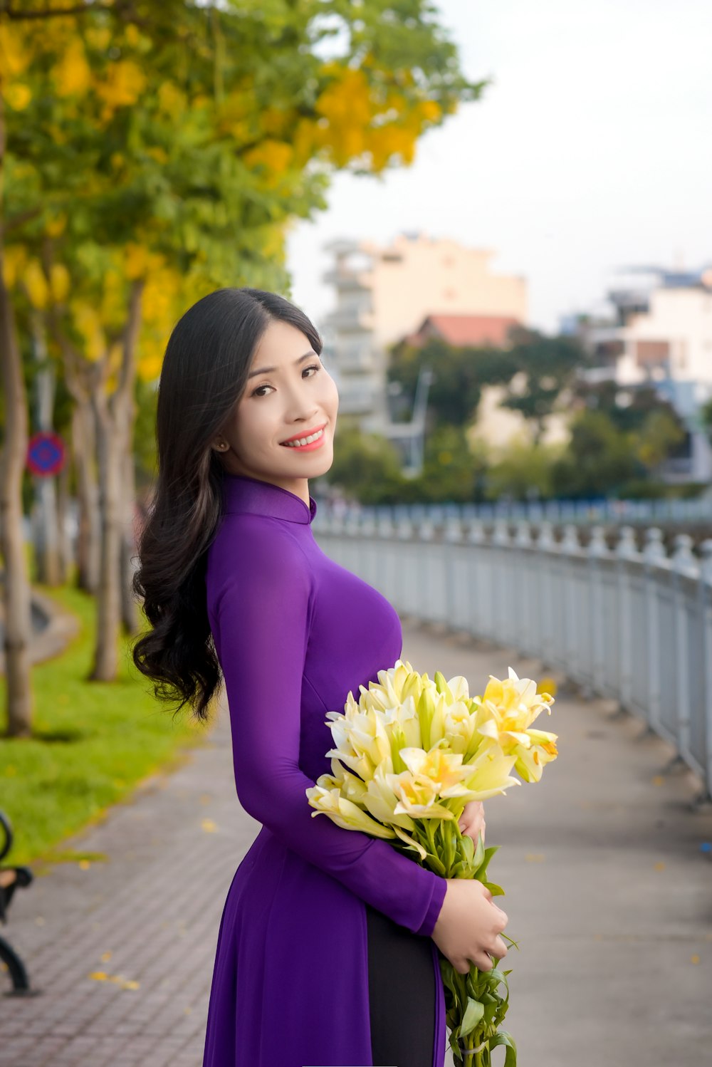 woman in purple long sleeve shirt holding bouquet of flowers