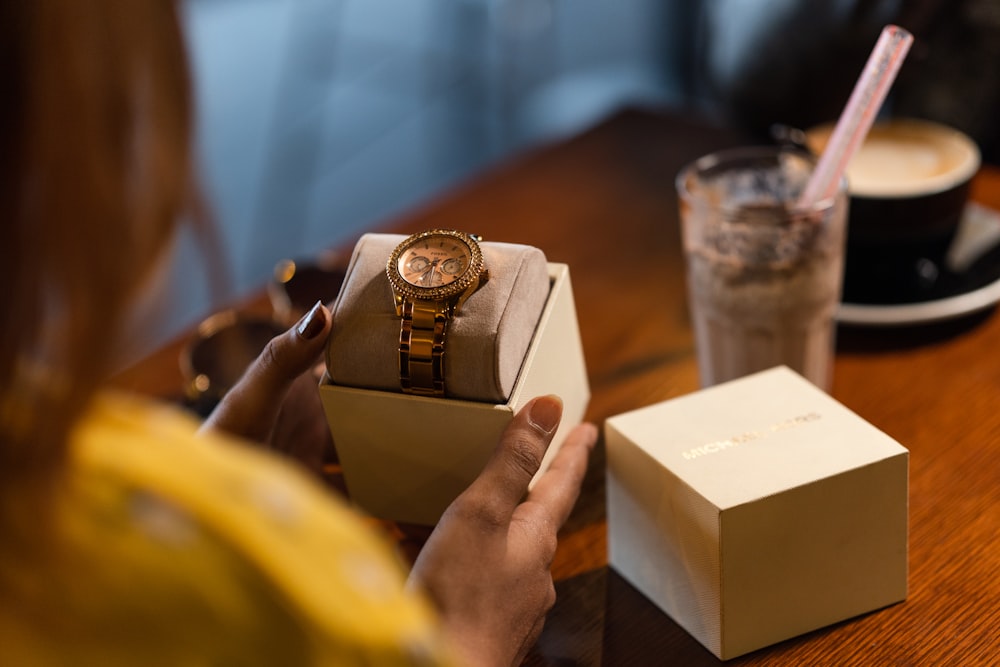 gold and silver chronograph watch in box
