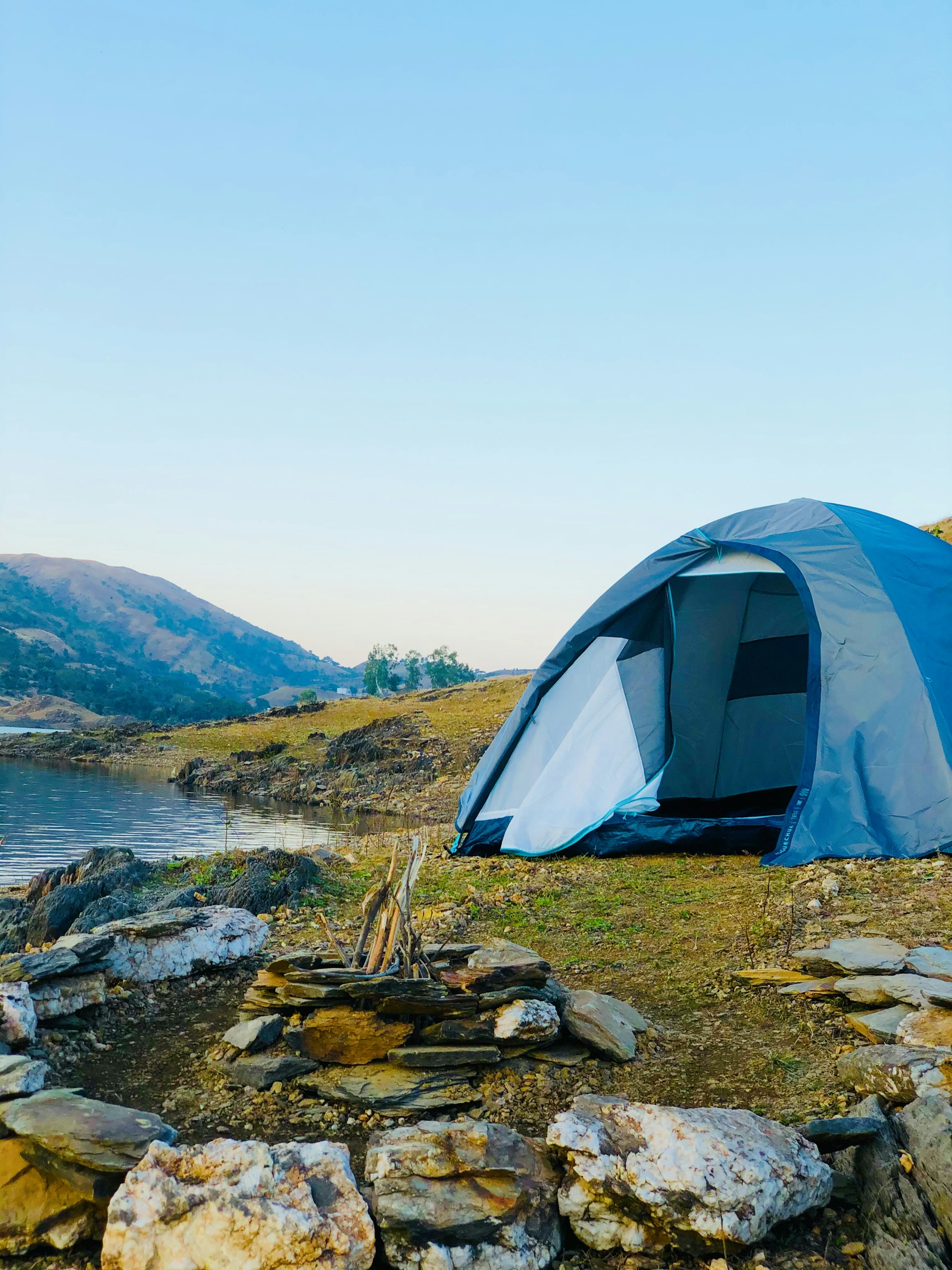 white dome tent on green grass field near body of water during daytime