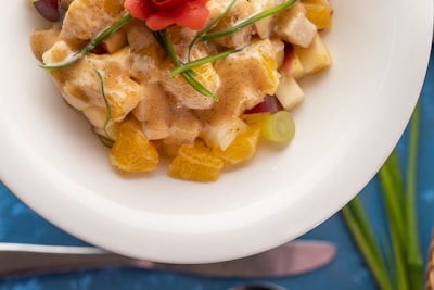 A close-up of a fruit salad topped with honey and nuts.