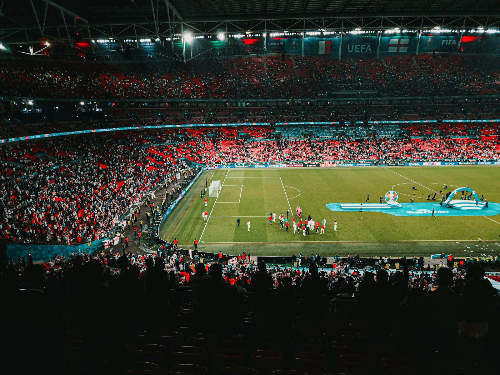 Fans in the stands watching a football game from the upper deck