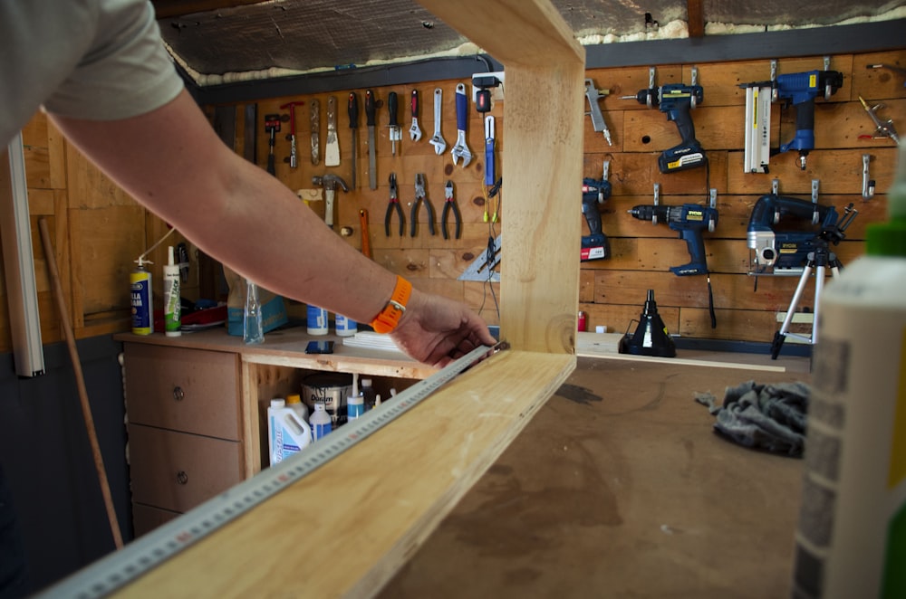 persona che tiene la cornice di legno marrone