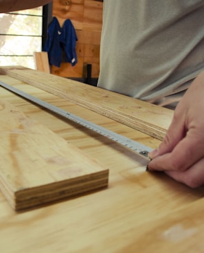 person in white shirt holding brown wooden table