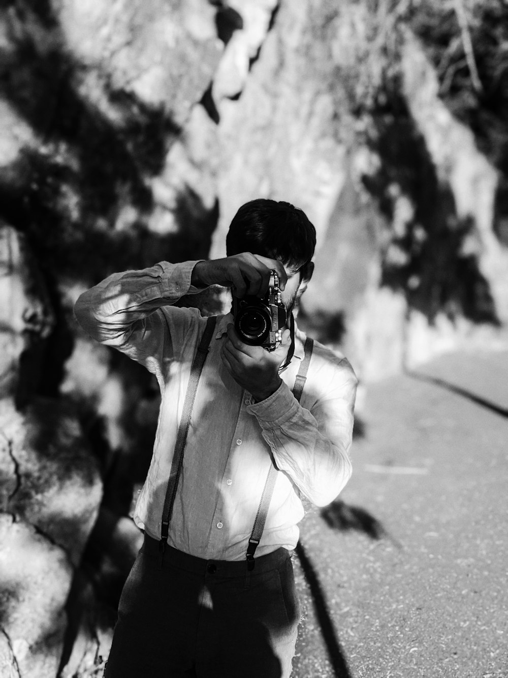 man in white dress shirt holding camera