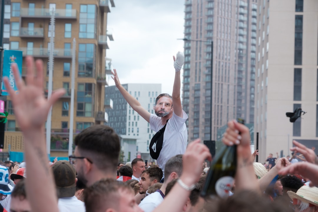 people in white shirts raising hands during daytime