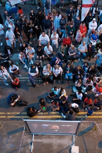 A diverse group of people watching a live sports match on mobile devices.