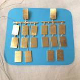 Close-up of silver geometric earrings with sharp edges on a neutral background.