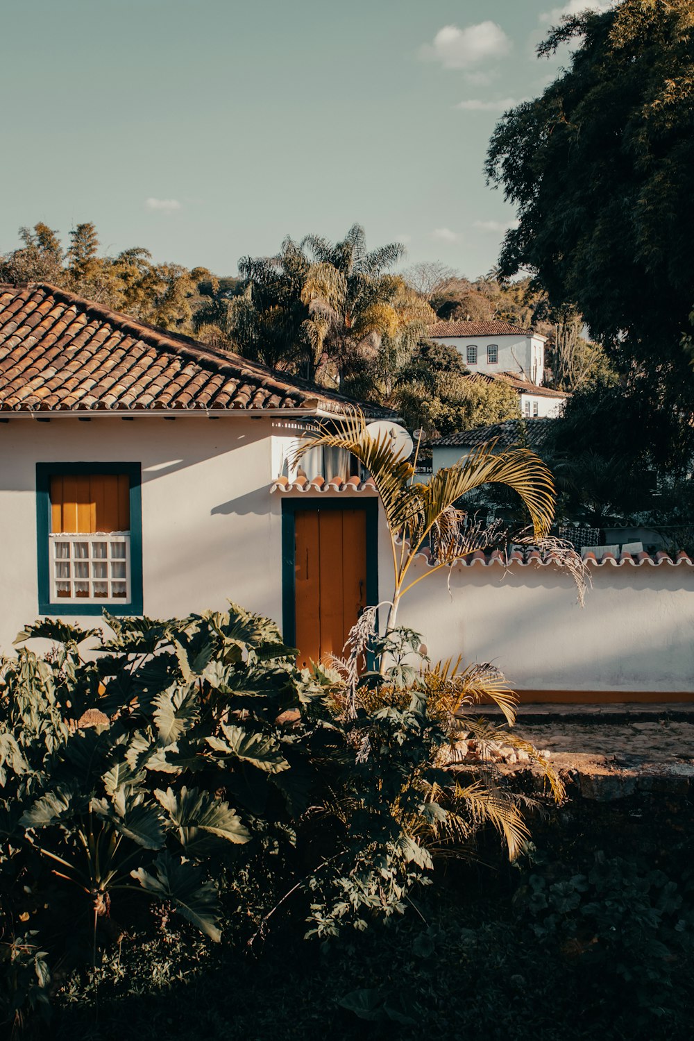 white and brown house near green trees during daytime