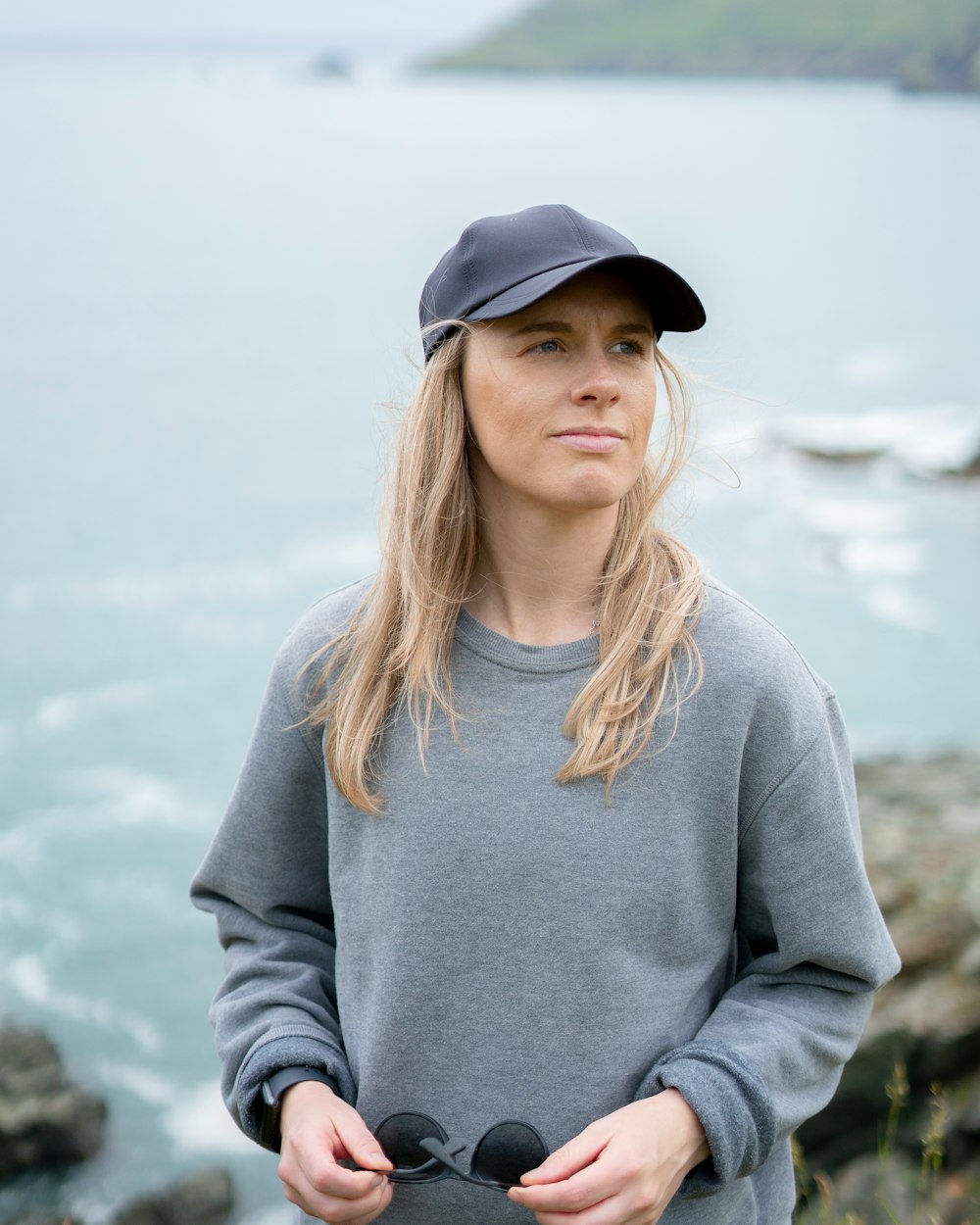 woman in gray long sleeve shirt and black cap