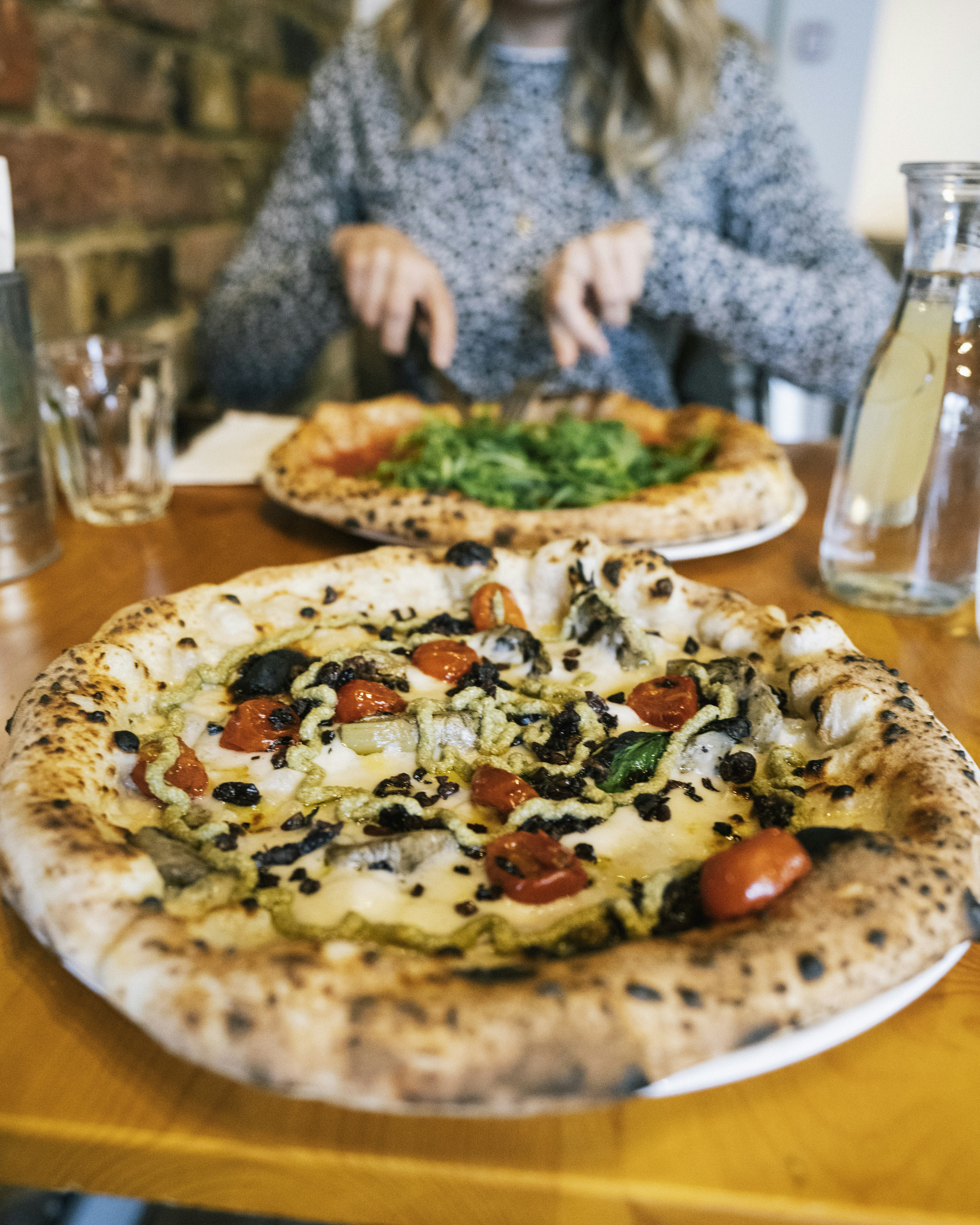 pizza com vegetal de folha verde na placa de cerâmica branca