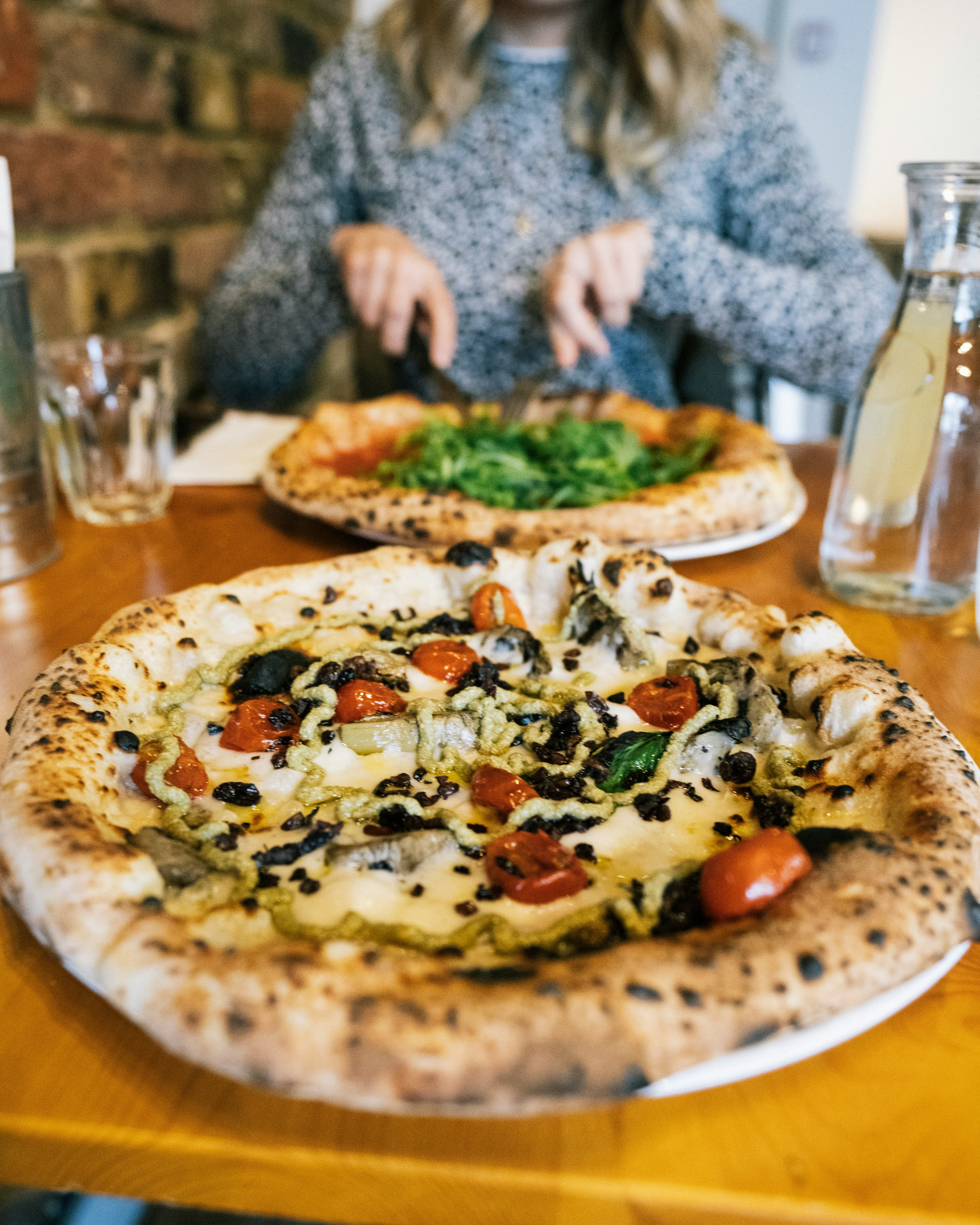 pizza with green leaf vegetable on white ceramic plate