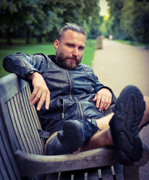 man in blue denim jacket sitting on bench